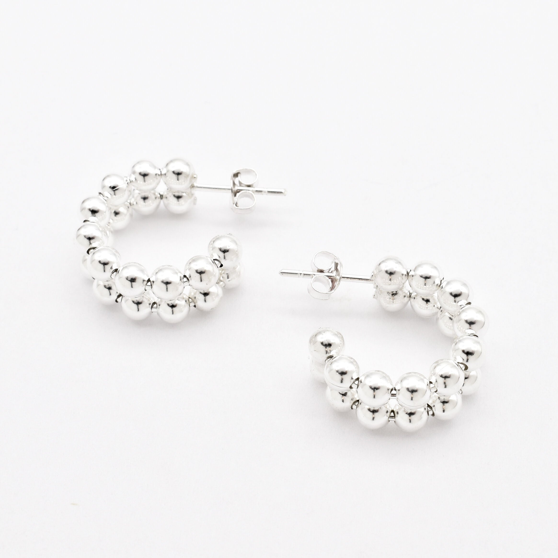 Top-down view of solid 925 sterling silver beaded hoop earrings with ball design