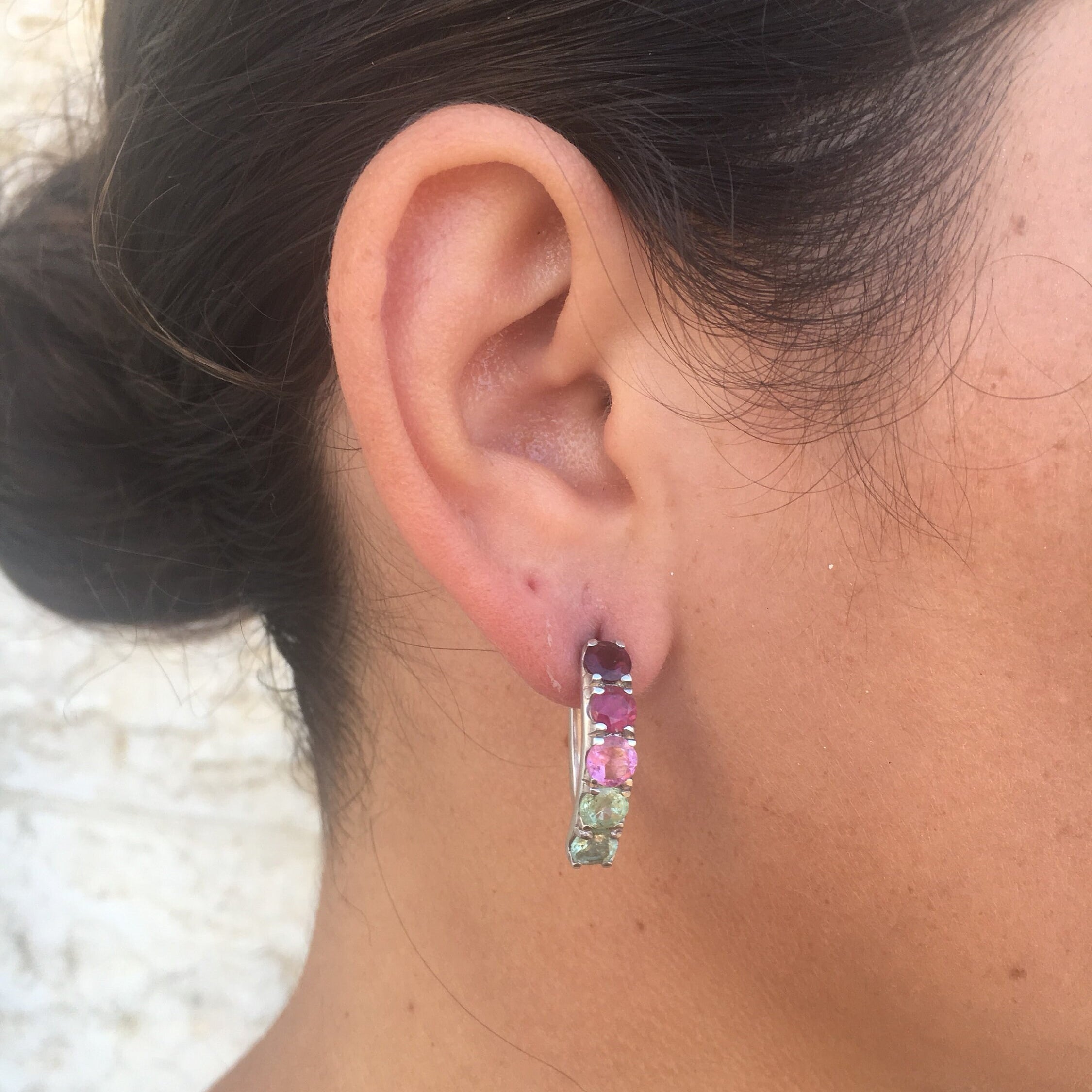 Tourmaline earrings in a spectrum of colors styled with a sleek low bun, adding vibrant gemstone sparkle that pairs beautifully with a minimalist black top for a polished daytime look