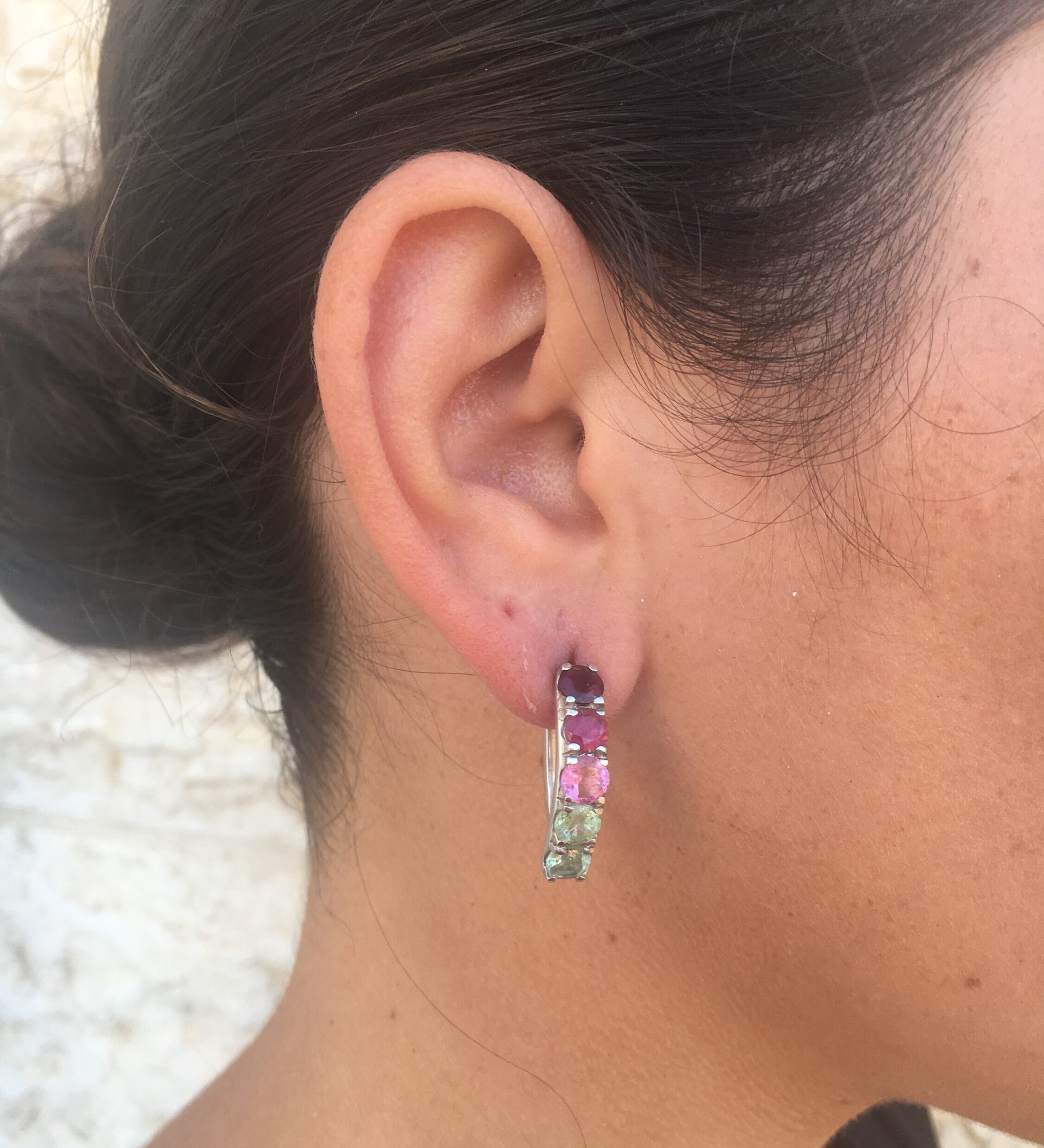 Tourmaline earrings in a spectrum of colors styled with a sleek low bun, adding vibrant gemstone sparkle that pairs beautifully with a minimalist black top for a polished daytime look