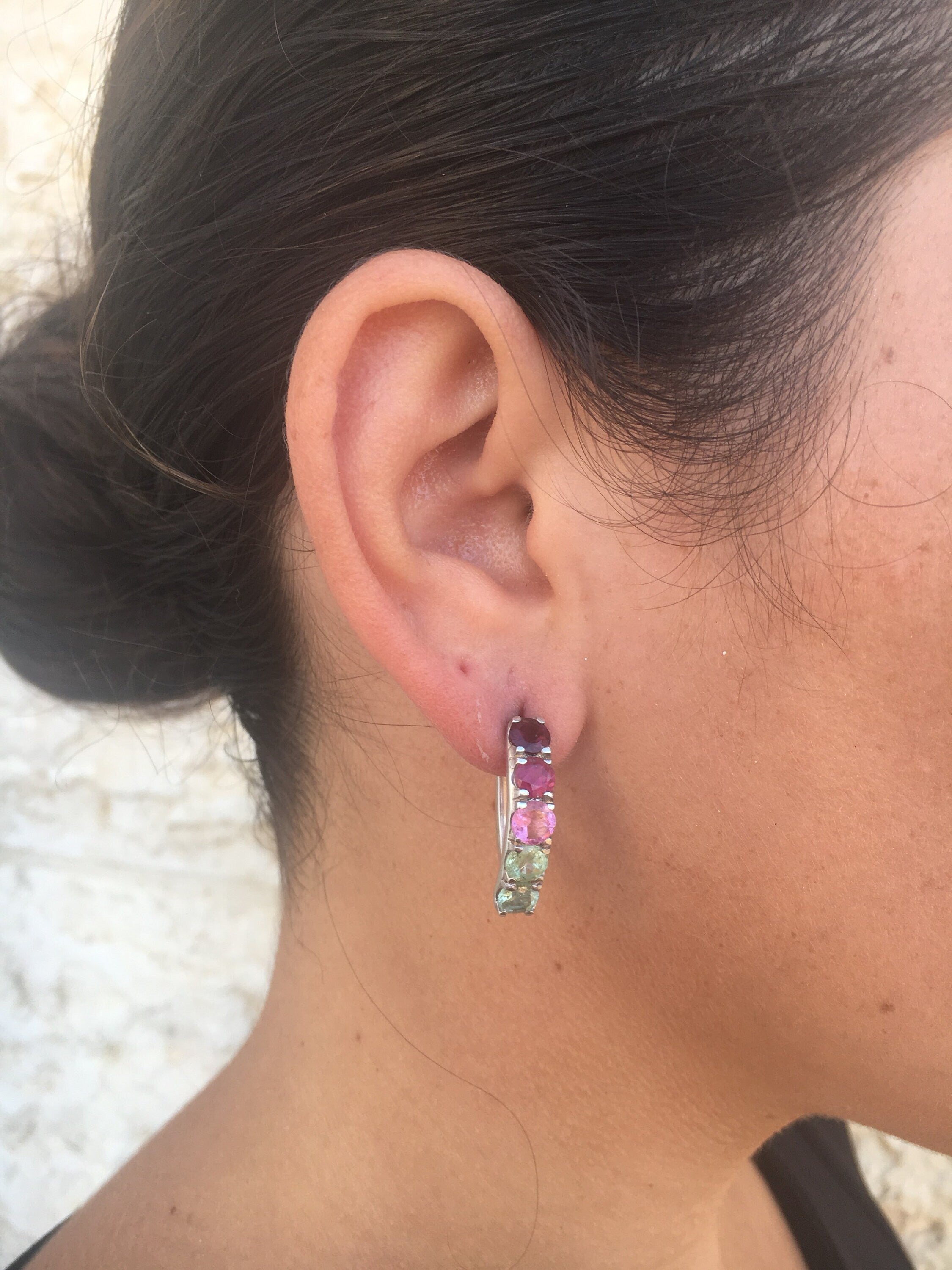 Tourmaline earrings in a spectrum of colors styled with a sleek low bun, adding vibrant gemstone sparkle that pairs beautifully with a minimalist black top for a polished daytime look