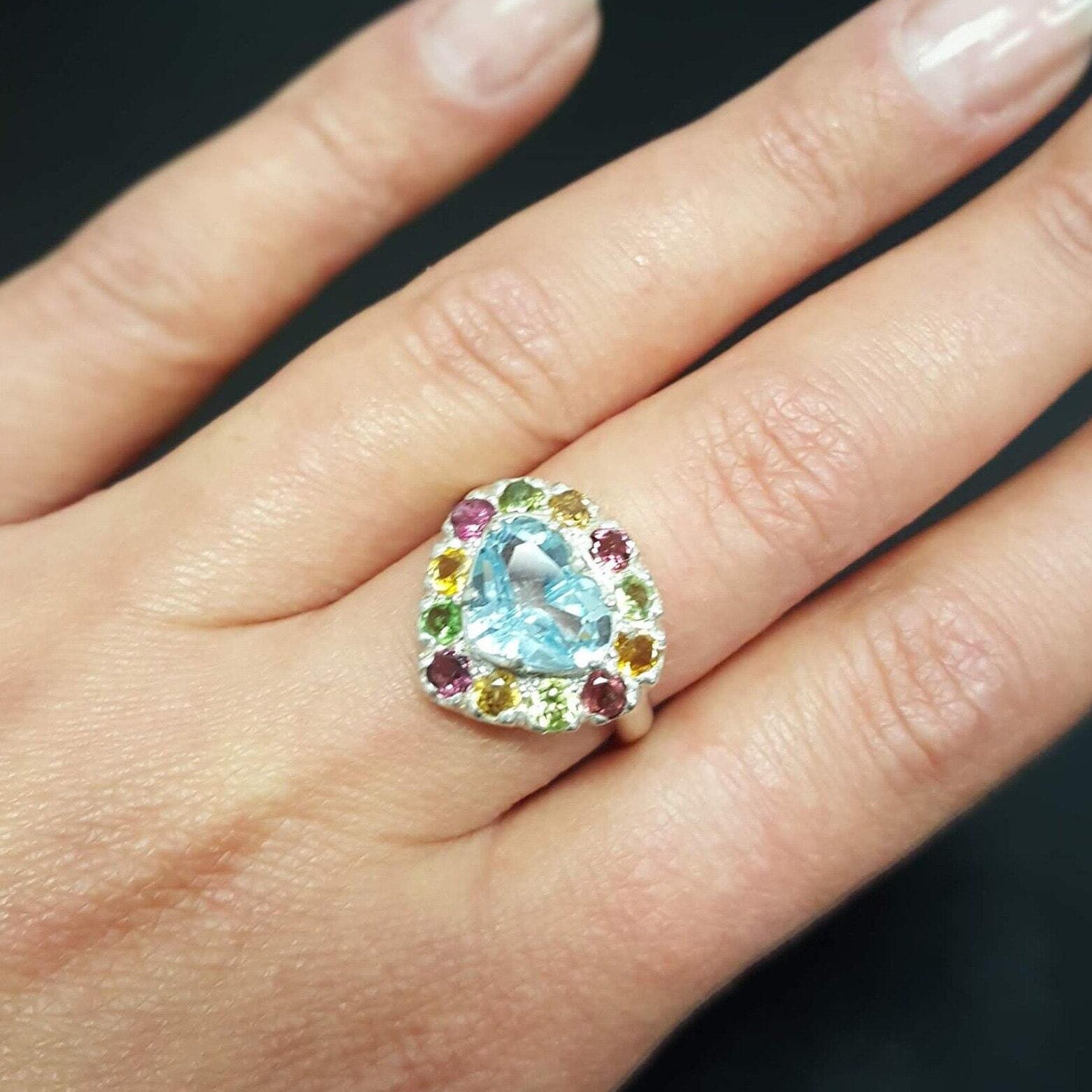 Blue Topaz ring styled on the ring finger, this heart-shaped multicolor gemstone ring pairs beautifully with a natural manicure and looks stunning for date nights or brunch styling.