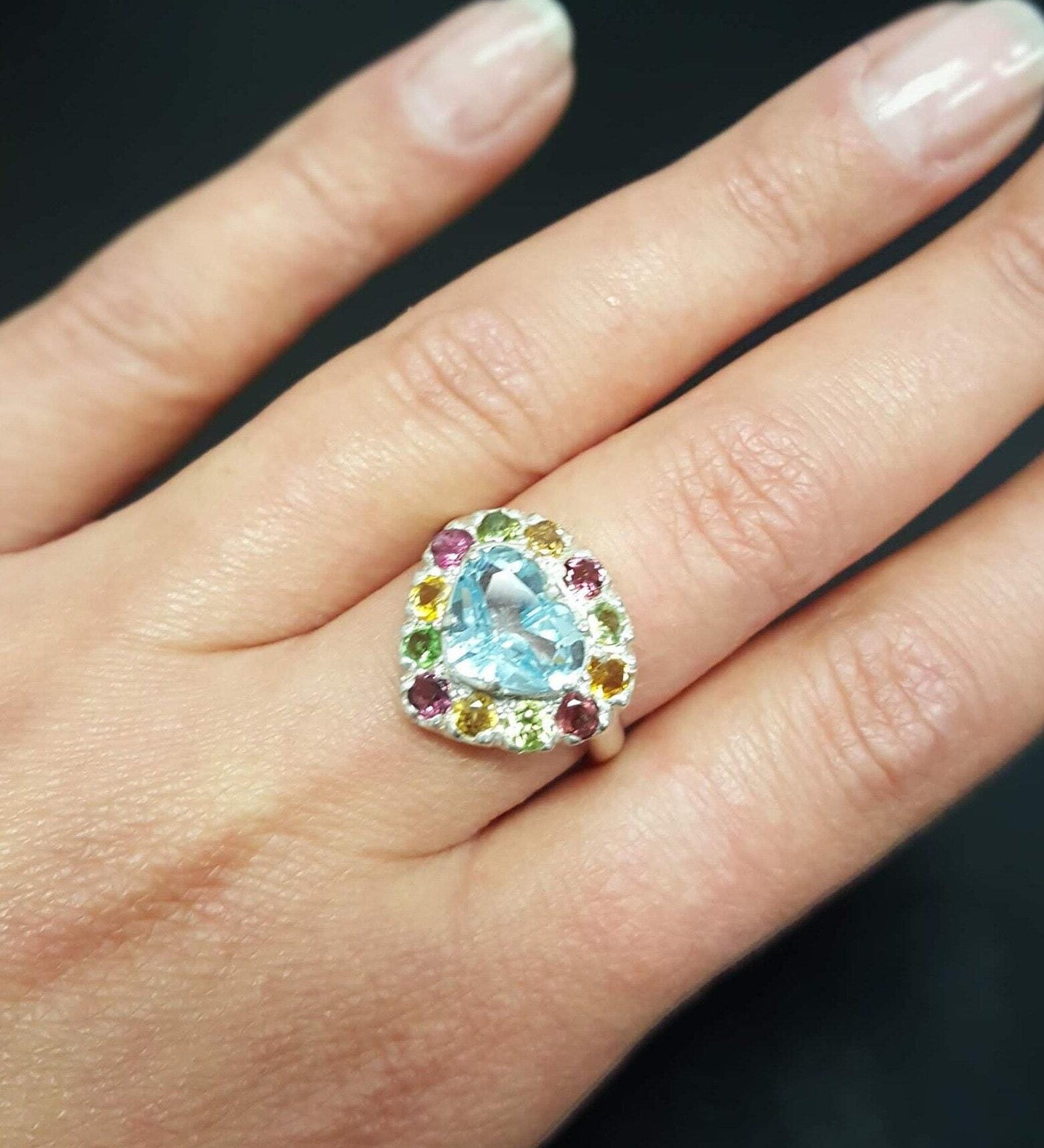 Blue Topaz ring styled on the ring finger, this heart-shaped multicolor gemstone ring pairs beautifully with a natural manicure and looks stunning for date nights or brunch styling.