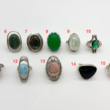 picture of ten rings: green jasper ring, labradorite ring, created emerald ring, prehnite ring, created emerald ring, raspberry color  rhodochrosite ring with vintage detail, long design Larimar ring with beautiful pattern on the stone, rhodochrosite ring with pattern, rare obsidian ring with soft blue flash, raspberry rhodochriosite ring in bezel setting