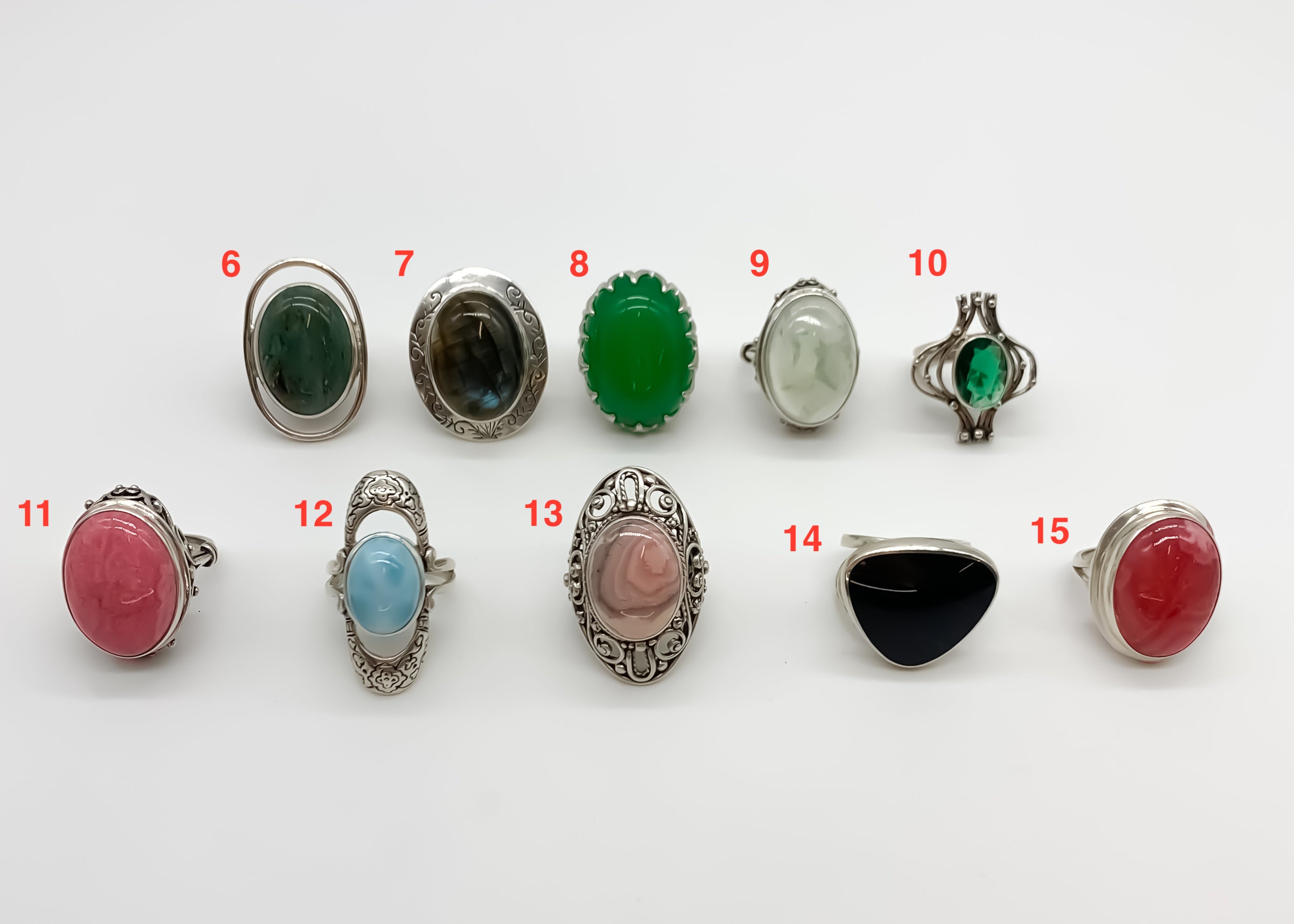 picture of ten rings: green jasper ring, labradorite ring, created emerald ring, prehnite ring, created emerald ring, raspberry color  rhodochrosite ring with vintage detail, long design Larimar ring with beautiful pattern on the stone, rhodochrosite ring with pattern, rare obsidian ring with soft blue flash, raspberry rhodochriosite ring in bezel setting