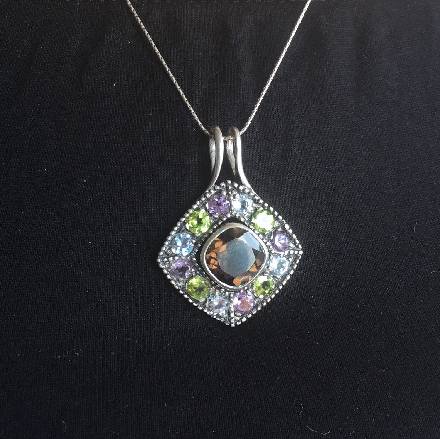 Smoky Topaz statement pendant worn over a black crew neck top—adds vivid contrast and bold sparkle, perfect for elegant casual days