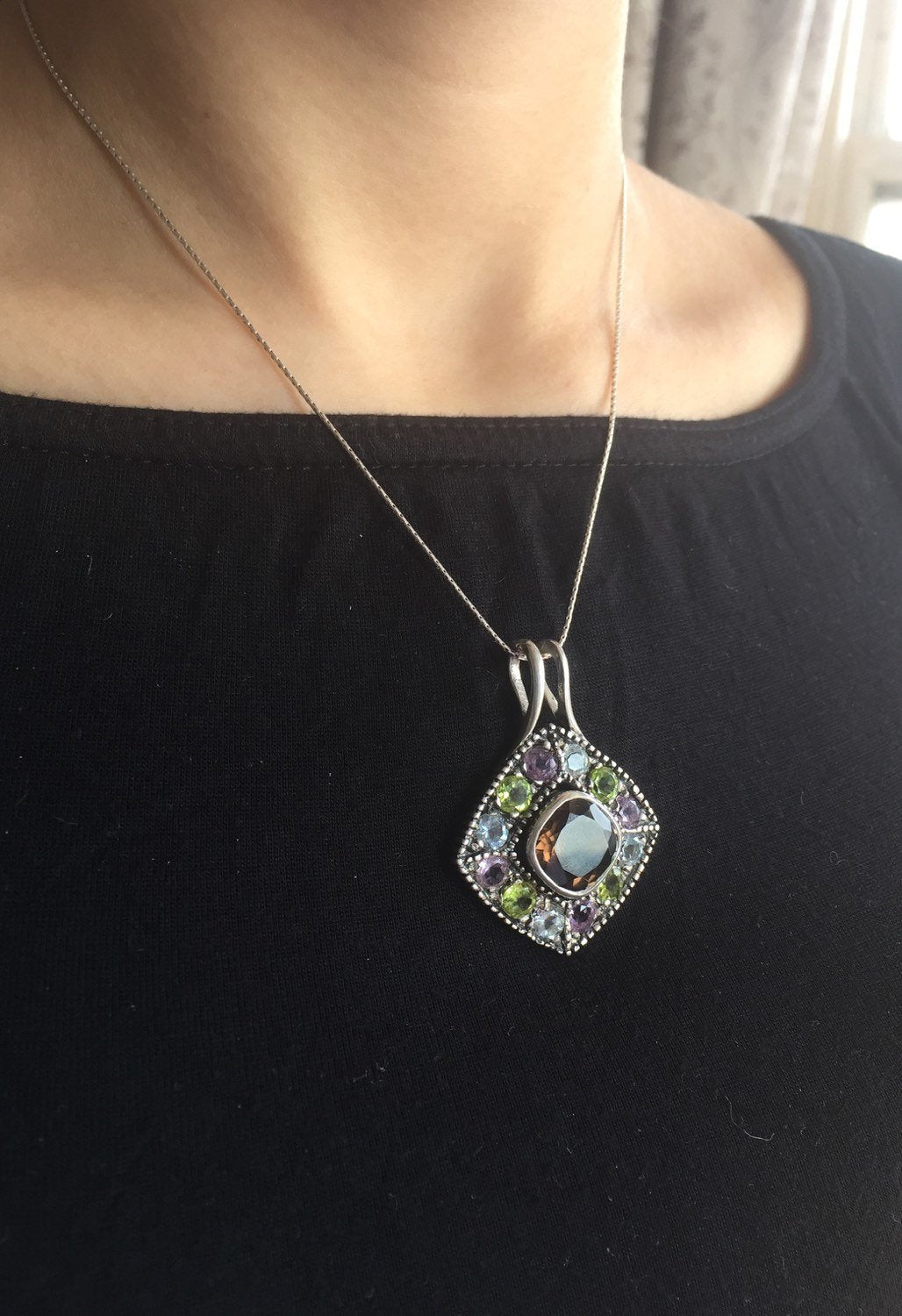 Smoky Topaz statement pendant worn over a black crew neck top—adds vivid contrast and bold sparkle, perfect for elegant casual days